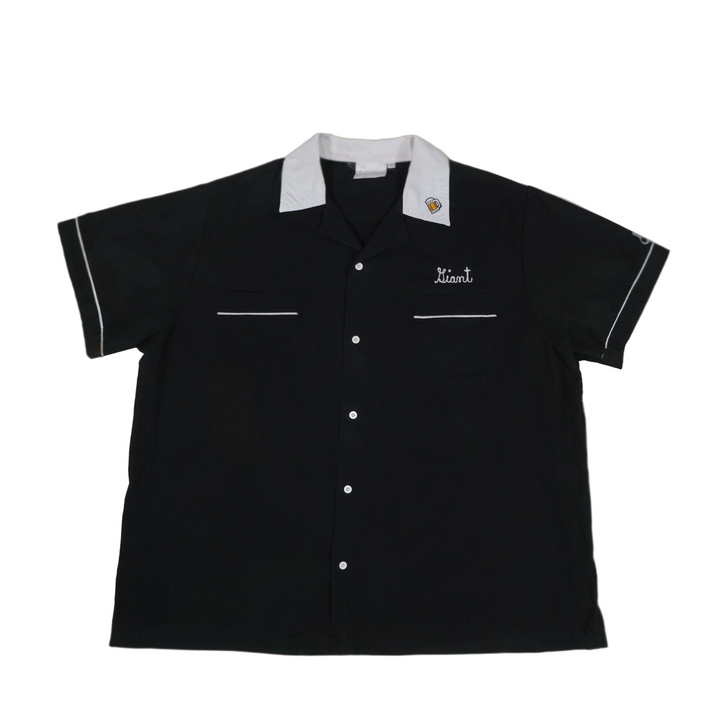 Black short-sleeve shirt with white trim on a beige background