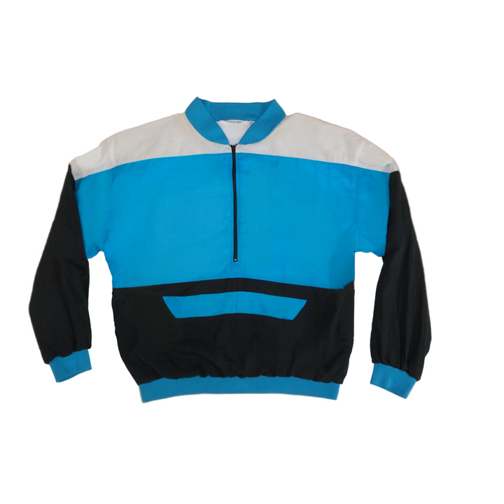 Color-blocked wind breaker jacket with blue, black, and white sections on a beige background